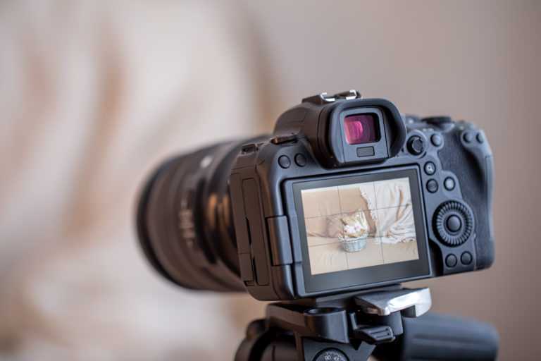 Close up professional digital camera on a tripod on a blurred background. The concept of technology for working with photos and videos.